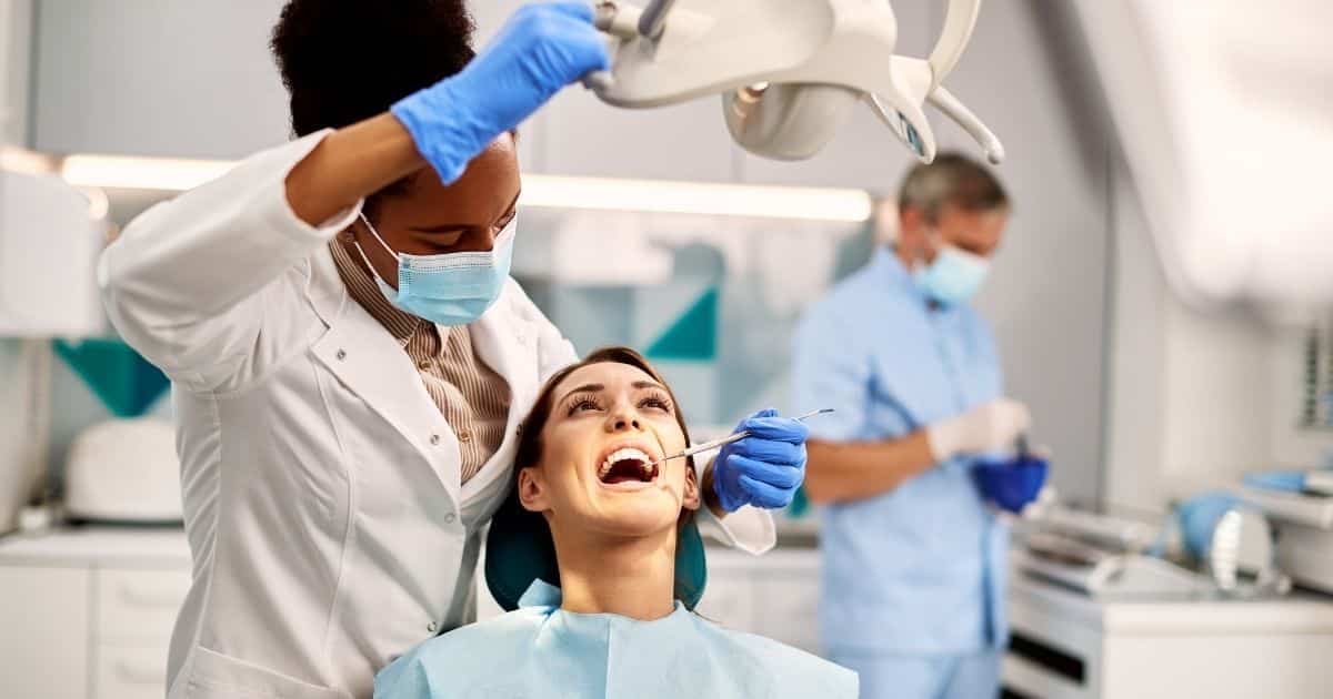 Dentist examining a patient’s teeth during a routine dental consultation in a modern clinic.